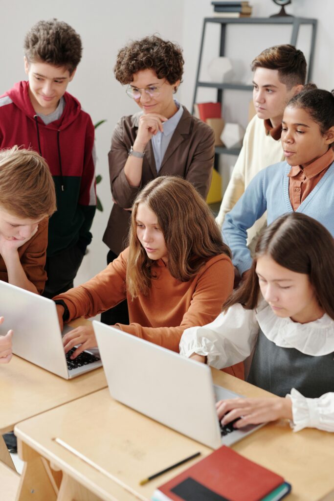 A Two Girls Using Laptop with Classmates